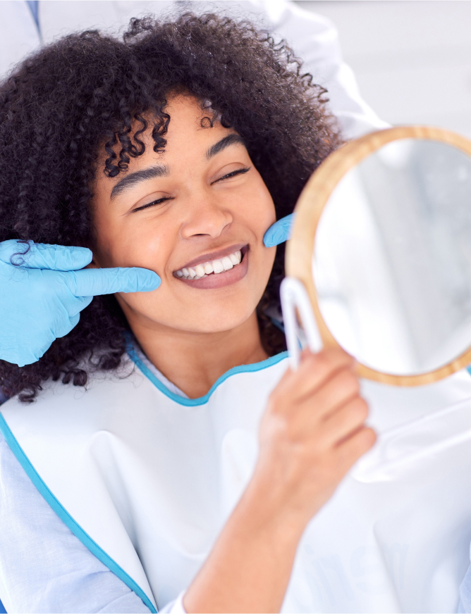 Woman looking at her new smile at the dentist