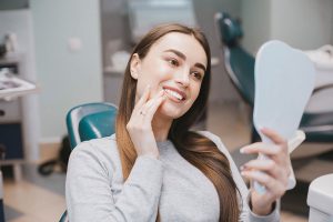 Woman looking at her smile at the dentist