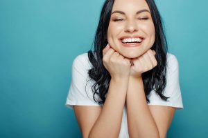 Smiling woman with healthy teeth, showcasing joy and confidence, representing the importance of oral health during Thanksgiving celebrations.